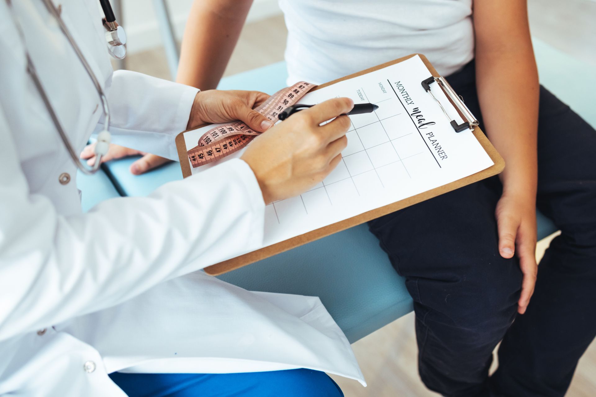 A Doctor Is Writing On A Clipboard | Frisco, TX | Signature Internal Medicine